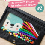 Un enfant assis en voiture jouant avec un busy bag rempli d'activités