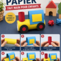 Un train en papier fait main coloré pour les enfants, posé sur une table de bricolage.