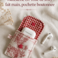 Un étui matelassé pour AirPods en Toile de Jouy posé sur une table en bois